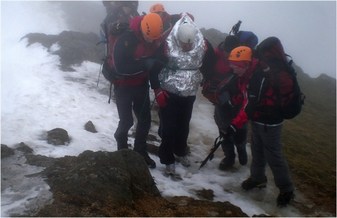 Picture of woman being evacuated by seatch and rescue team